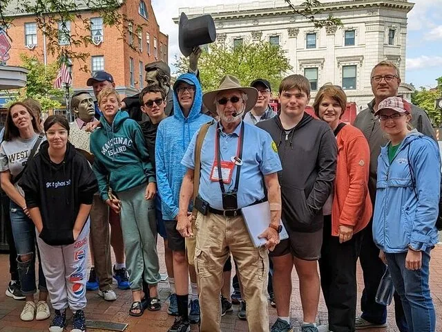Tour group with guide in town square with statues