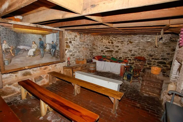 Cellar interior at Jennie Wade House with wooden benches and displays